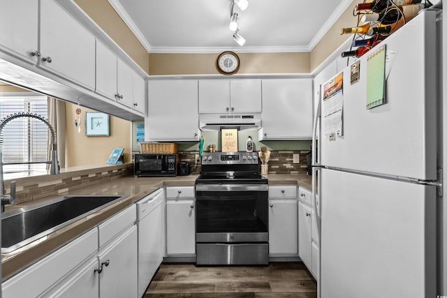 kitchen with crown molding, under cabinet range hood, white cabinets, white appliances, and a sink