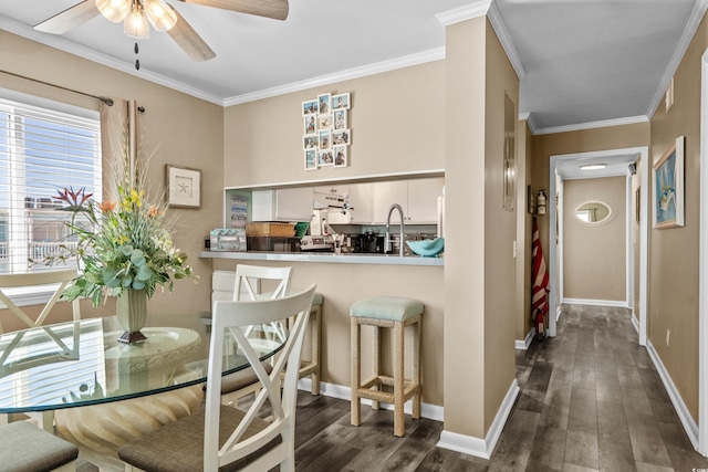 dining area with dark wood-style floors, baseboards, and ornamental molding