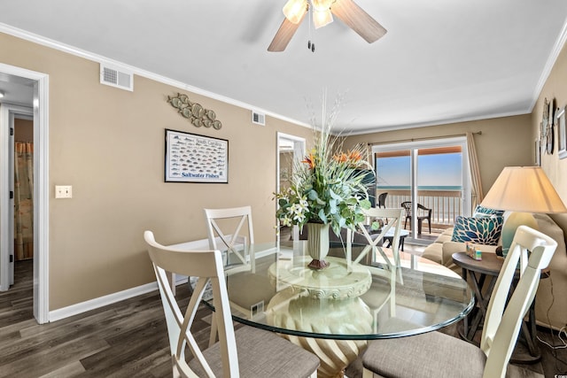 dining area featuring crown molding, wood finished floors, visible vents, and baseboards