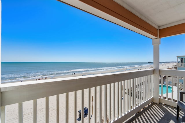 balcony featuring a beach view and a water view