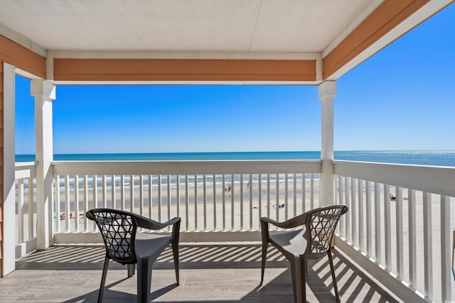 balcony featuring a beach view and a water view