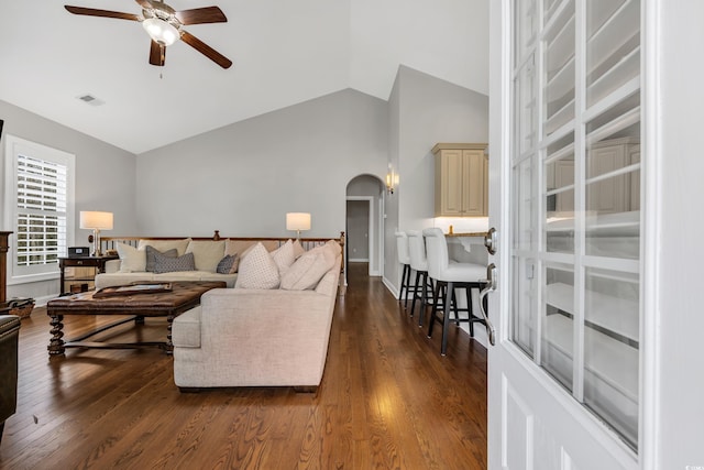 living room with visible vents, arched walkways, dark wood-style flooring, and ceiling fan