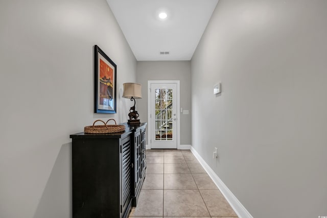 doorway to outside with light tile patterned floors, visible vents, and baseboards