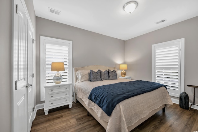 bedroom featuring visible vents, baseboards, and wood finished floors