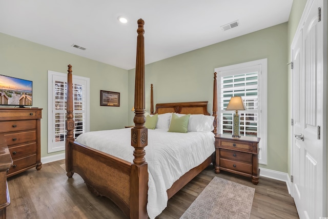 bedroom featuring wood finished floors, visible vents, and baseboards