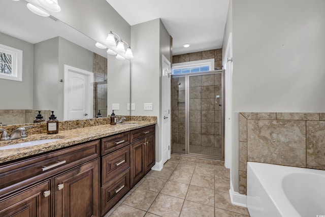 bathroom with a shower stall, tile patterned floors, double vanity, a bath, and a sink