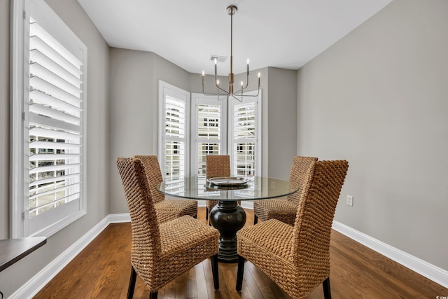 dining space featuring an inviting chandelier, visible vents, baseboards, and dark wood-type flooring