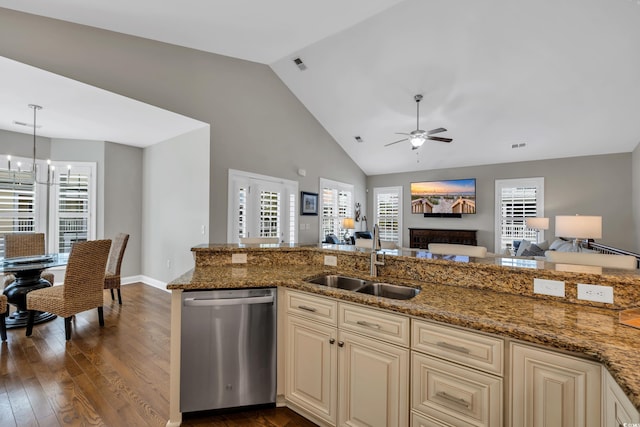 kitchen with a sink, dark wood-type flooring, cream cabinetry, stainless steel dishwasher, and open floor plan