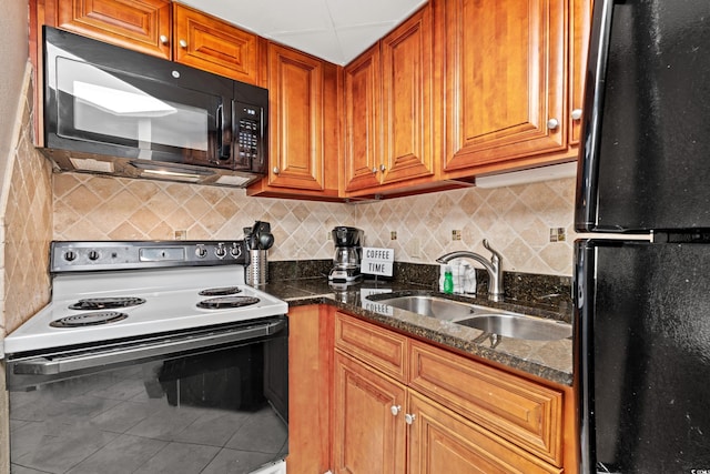 kitchen featuring tile patterned flooring, backsplash, brown cabinetry, black appliances, and a sink