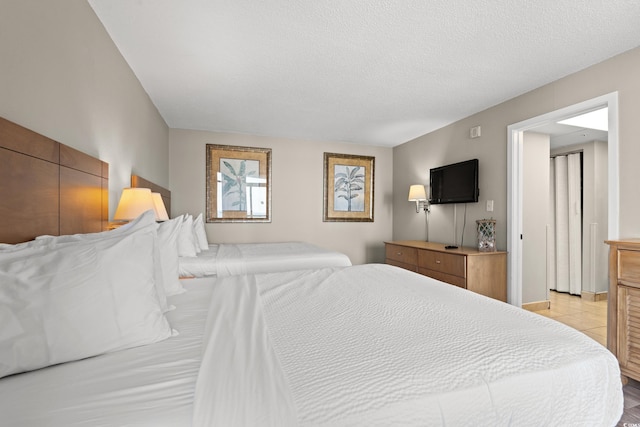 bedroom with light tile patterned floors and a textured ceiling