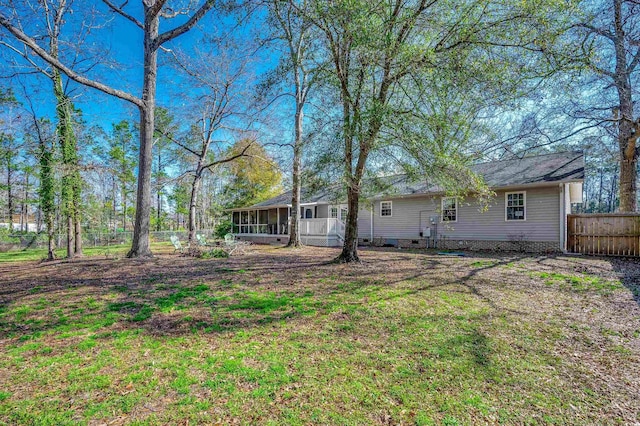 view of yard featuring fence and a sunroom