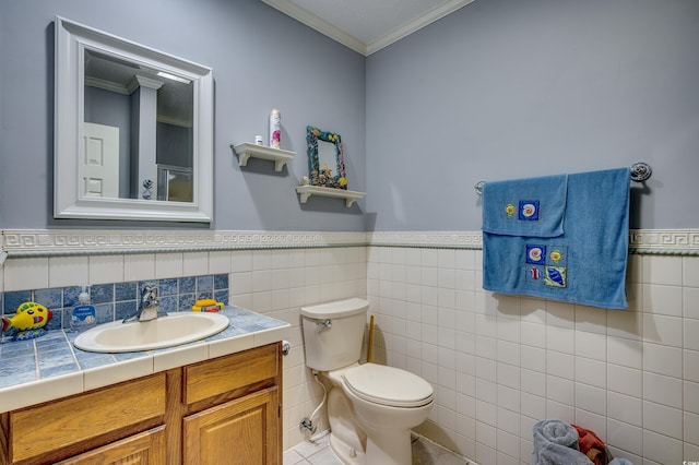 bathroom featuring tile walls, crown molding, toilet, and vanity