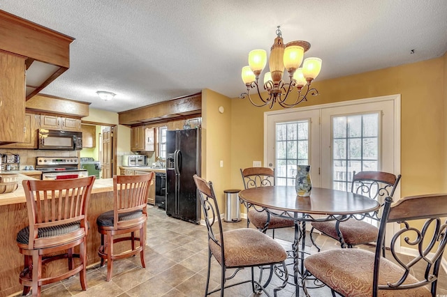 dining area featuring light tile patterned floors, baseboards, a textured ceiling, and an inviting chandelier