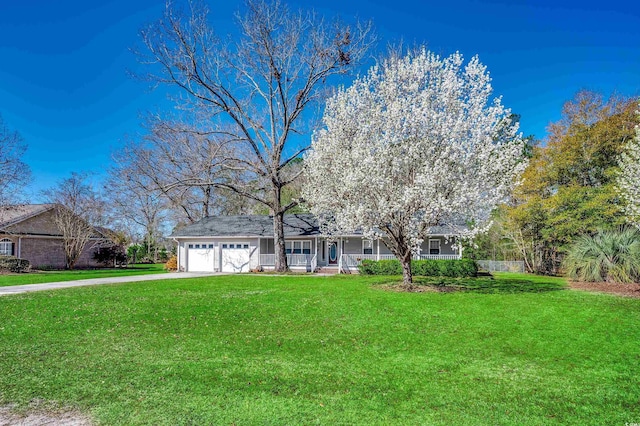 view of front of home featuring a front yard, concrete driveway, covered porch, and a garage