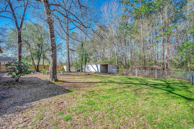 view of yard featuring an outbuilding, a fenced backyard, a garage, and a shed