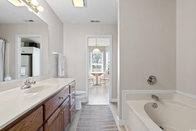 2029 Hawksmoor Dr, Conway, SC 29526 - bathroom featuring a bath, a textured ceiling, vanity, visible vents, and toilet