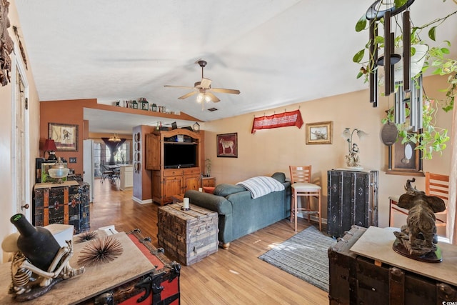 living area with a ceiling fan, lofted ceiling, and light wood-style floors