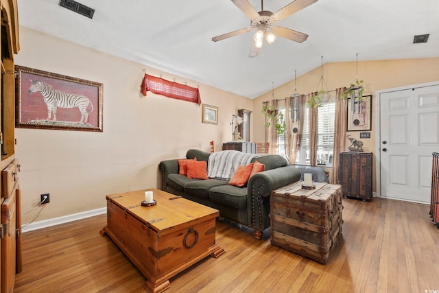 living area with visible vents, a ceiling fan, lofted ceiling, and hardwood / wood-style flooring