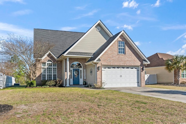 traditional-style house with brick siding, roof with shingles, concrete driveway, and a front lawn