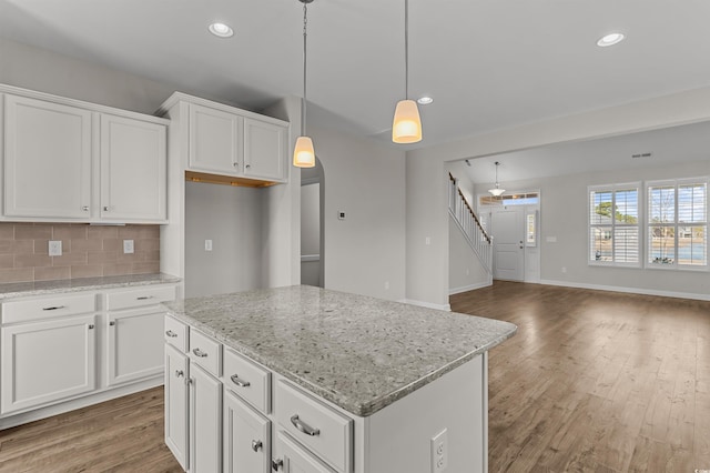 kitchen with recessed lighting, backsplash, white cabinets, and wood finished floors