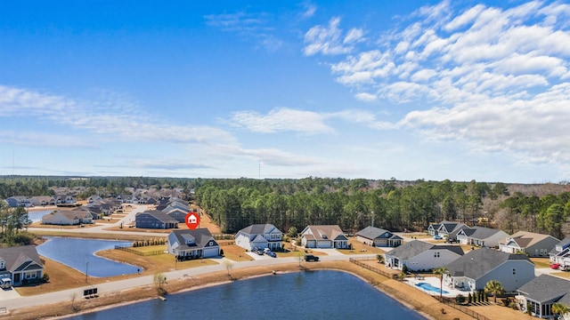 drone / aerial view with a residential view, a forest view, and a water view