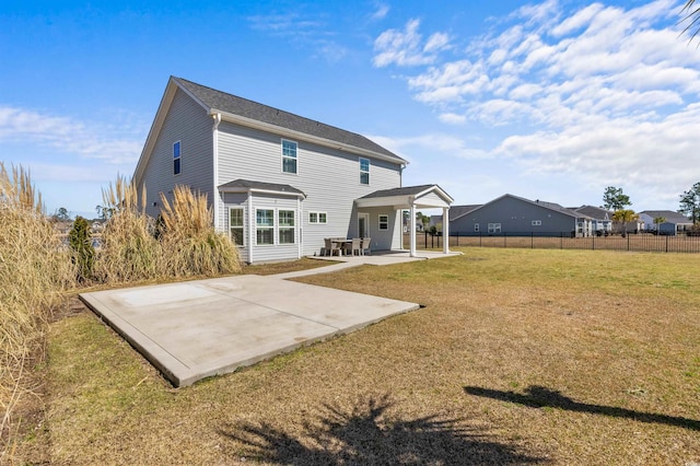 rear view of house with a patio area, a yard, and fence