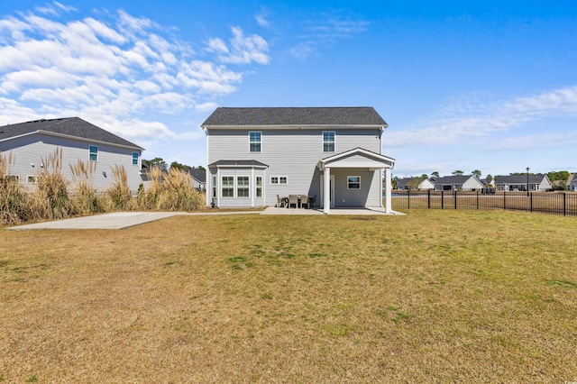 back of property featuring a lawn, a patio, and fence