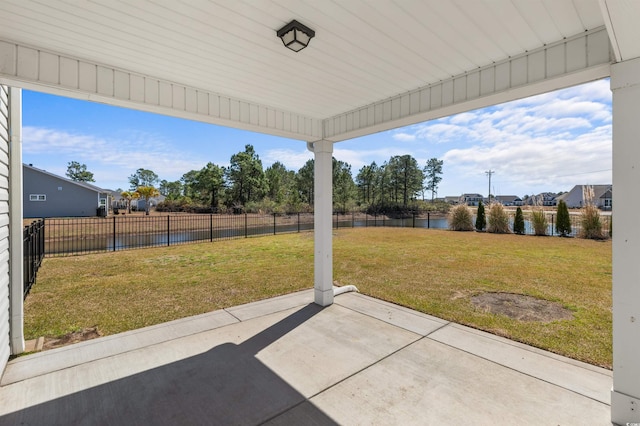 view of patio with fence and a water view