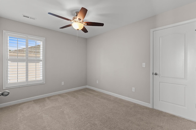 carpeted empty room featuring visible vents, baseboards, and ceiling fan