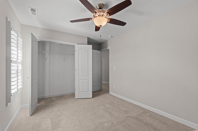 unfurnished bedroom featuring visible vents, light carpet, a ceiling fan, a closet, and baseboards