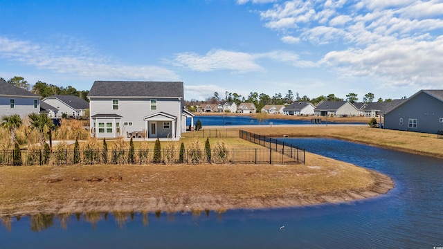 exterior space featuring a residential view, a water view, and fence