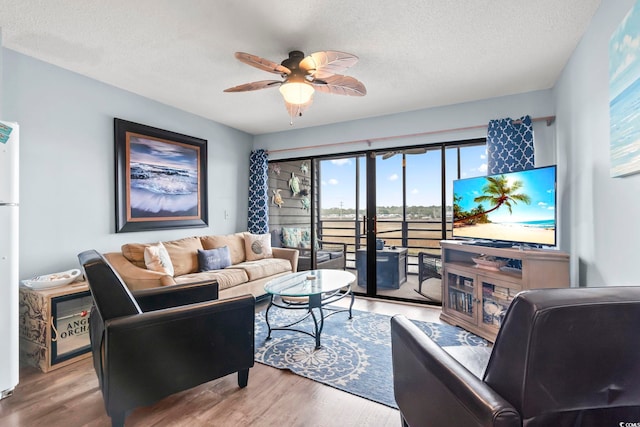 living area featuring a textured ceiling, wood finished floors, and ceiling fan