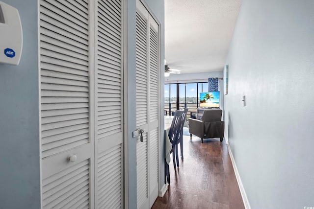 corridor with wood finished floors and baseboards