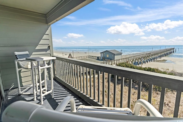balcony featuring a view of the beach and a water view