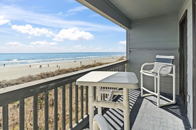 balcony featuring a beach view and a water view
