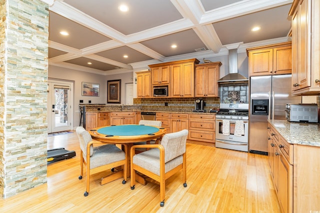 kitchen with wall chimney range hood, beamed ceiling, light wood-style flooring, appliances with stainless steel finishes, and coffered ceiling