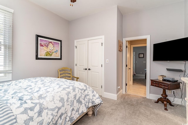 bedroom with a closet, baseboards, ceiling fan, and carpet flooring