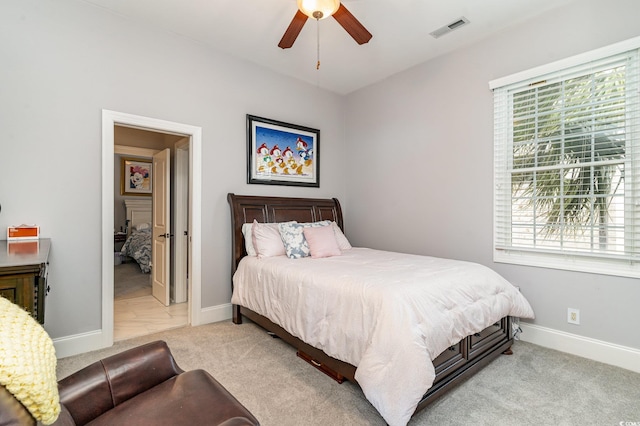 bedroom with visible vents, baseboards, light colored carpet, and ceiling fan