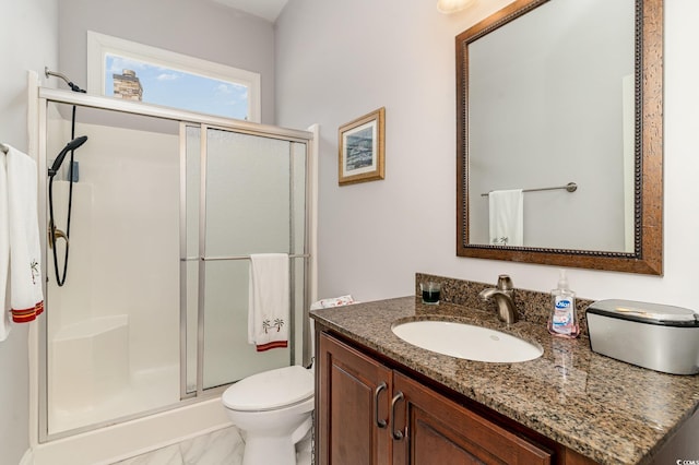 full bathroom with vanity, toilet, a stall shower, and marble finish floor