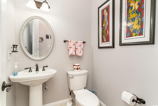 bathroom featuring baseboards and toilet