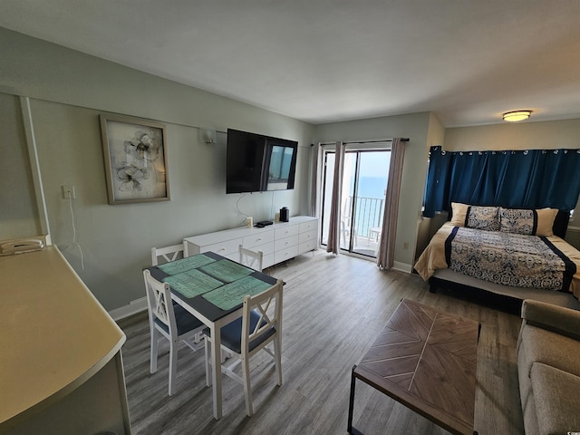 bedroom featuring access to exterior, wood finished floors, and baseboards