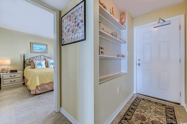 hall featuring light tile patterned floors and baseboards