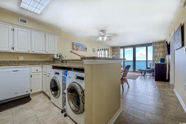 laundry area featuring visible vents, ceiling fan, washer and clothes dryer, laundry area, and light tile patterned flooring