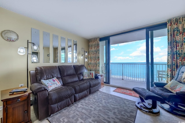 living room featuring light tile patterned floors, a water view, and expansive windows