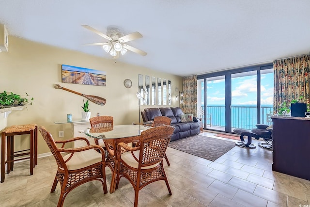 dining room with a wall of windows, light tile patterned floors, and a ceiling fan