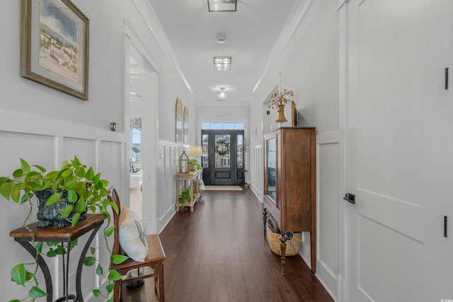 entryway featuring wainscoting, dark wood-style floors, crown molding, and a decorative wall