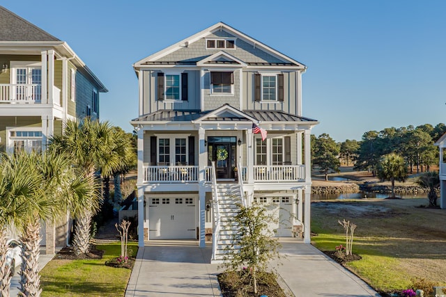 coastal home with driveway, a standing seam roof, a porch, board and batten siding, and stairs