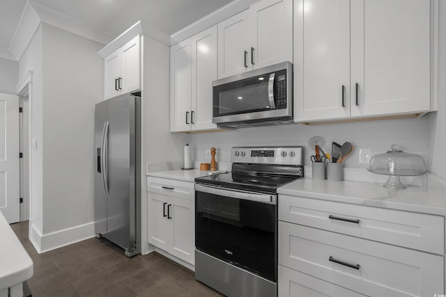 kitchen featuring white cabinets, stainless steel appliances, crown molding, and baseboards