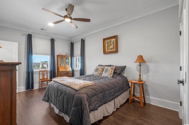 bedroom featuring visible vents, crown molding, baseboards, wood finished floors, and a ceiling fan