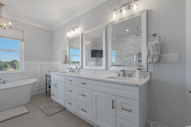 full bathroom with a sink, double vanity, walk in shower, and wainscoting